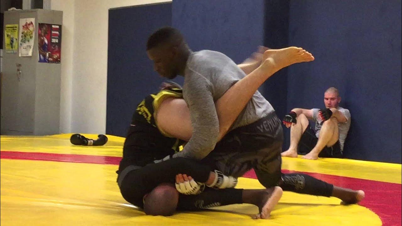 Deux pratiquants de MMA exécutent une technique de soumission au sol pendant un sparring, entraînement grappling – MMA Evolution